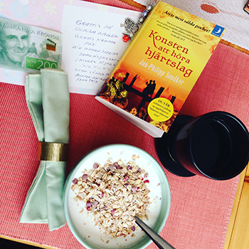 Frukost med namnsdagskort och bok, kaffe och fil med müsli Frukost med namnsdagskort och bok