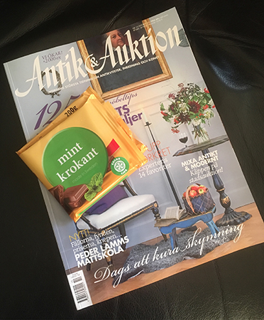Tidskriften Antik & Auktion och en bit Mintkrokantchoklad i papper Tidskriften Antik & Auktion och en bit Mintkrokantchoklad i papper