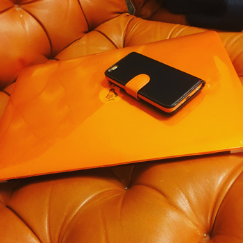 Orange dator med mobiltelefon ovanpå