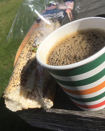 Macka i plast och kaffe i pappmugg.