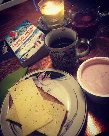 Frukost i Motala med kaffe, ostsmörgås, yoghurt, bok och tänt ljus Frukost i Motala med kaffe, ostsmörgås, yoghurt, bok och tänt ljus