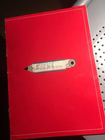 Röd skrivbok med titeln Släkten