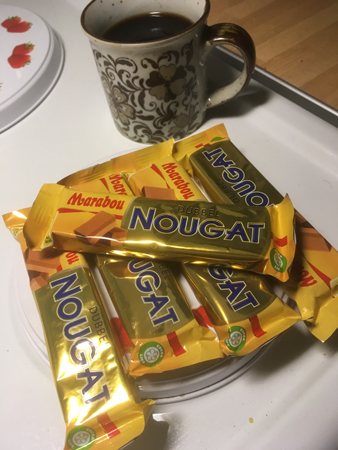 Fem nougatbitar och en mugg kaffe.