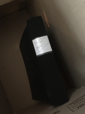 Pärm med texten "Ulrikas prylar" på ryggen i en låda