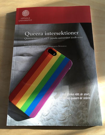 Skriften  Queera intersektioner och mobil med regnbågsskal