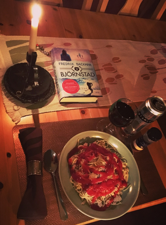 Pasta med vin öl bok och tänt ljus