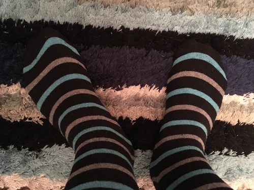 Randiga strumpor som färgmatchar badrumsmattan