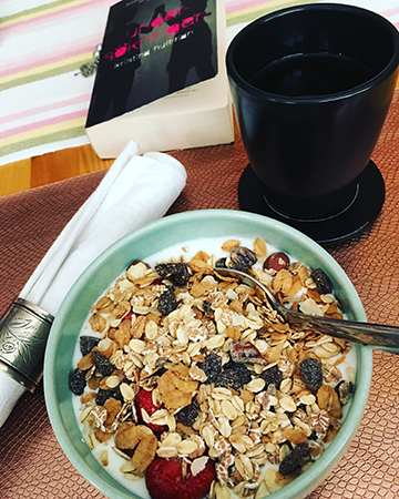 Frukost fil med müsli kaffe och bok
