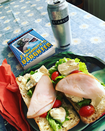 Macka öl och bok på balkongen