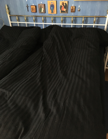 Säng med svarta lakan