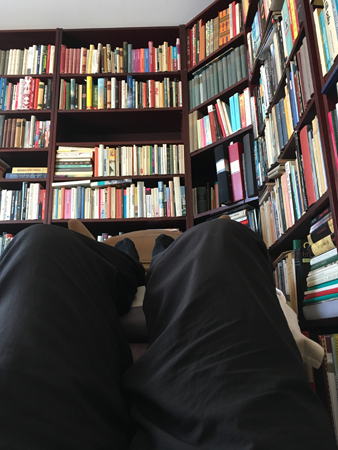 Bokhyllor och mina ben på en pall Bokhyllor och mina ben på en pall