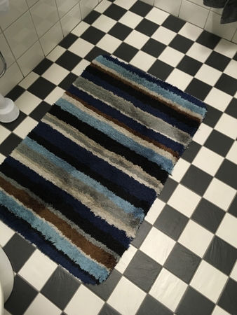 Randig matta på rutigt golv