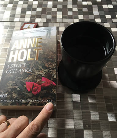 Boken I stoft och aska och kaffe på köksbordet