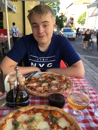 Elias äter pizza på Trattoria Alessandro