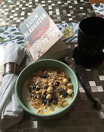 Frukost med bok kaffe och yoghurt med müsli