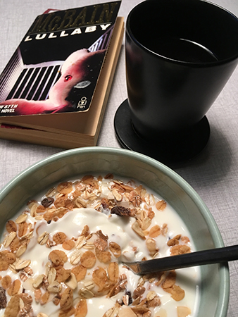 Frukost med yoghurt müsli kaffe och bok