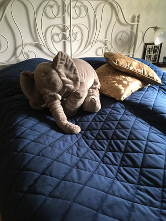 Bäddad säng med elefant och sidenkuddar