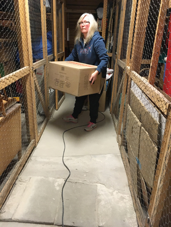 Anna bär en låda på vinden