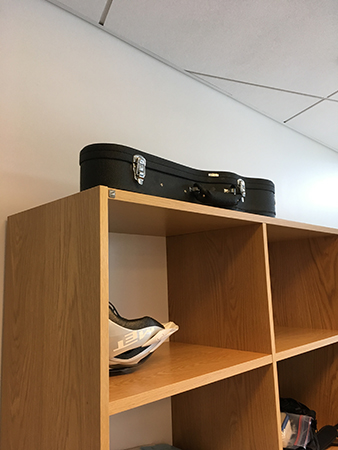 Instrumentfodral ovanpå hylla