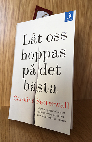 Boken Låt oss hoppas på det bästa i min bokhylla på jobbet
