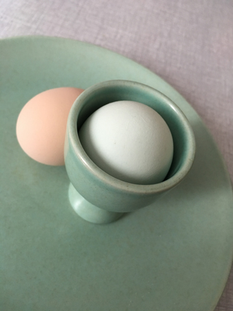Ett beige ägg och ett grönt