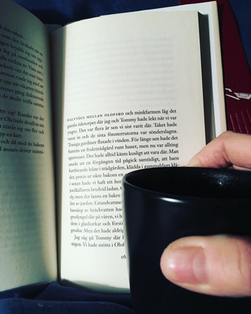 Uppslagen bok och kaffemugg