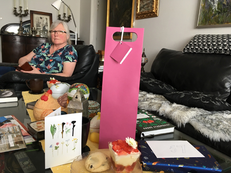 Anna med mobilen vid fika och presentbordet