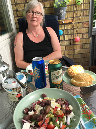 Anna äter sallad på balkongen