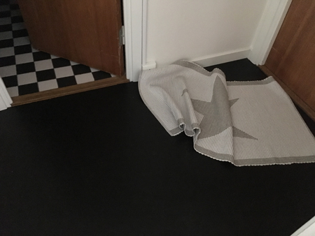 Ihoprullad matta vid sovrumsdörren