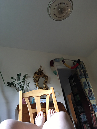 På golvet med fötterna upp på en stol