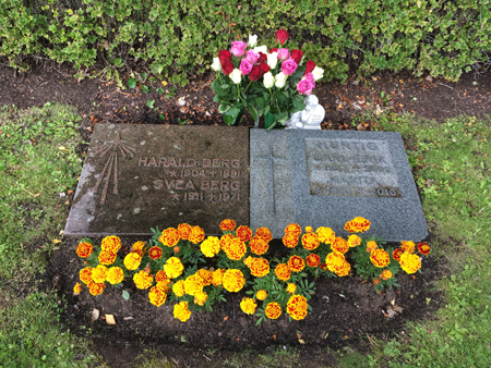 Påfyllt med röda och vita rosor på graven