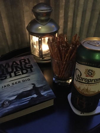 Balkongmys med bok öl salta pinnar och lykta