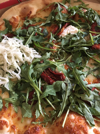 Pizza med mycket ruccola och lite ost