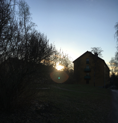 Solen går ner bakom husen