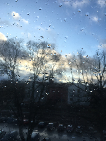 Regn men ljus himmel över parkeringen