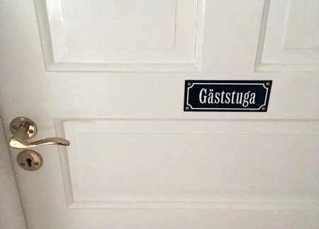 Vit dörr med skylt gäststuga