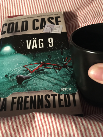 Bok och kaffemugg på sängen