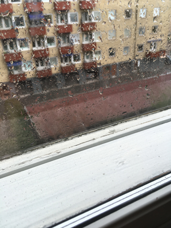 Regn på fönstret och huset mitt emot