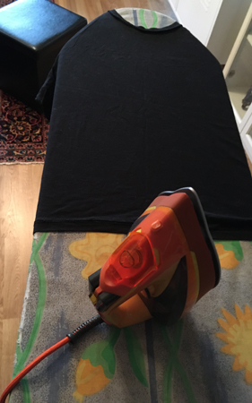 T-shirt och strykjärn på strykbrädan