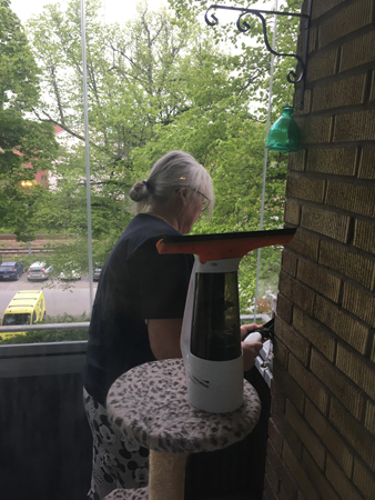 Anna putsar insidan av den inglasade balkongen