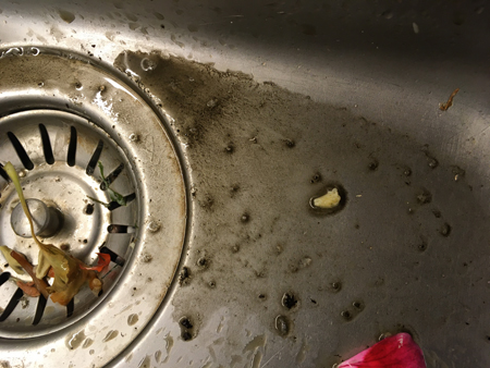 Avhällt smutsvatten från putsningen av utsidan av glasen på balkongen