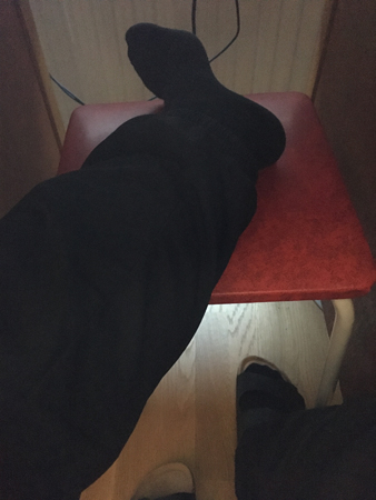 Mitt onda ben på en pall under skrivbordet hemma