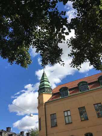 Under ett träd mitt emot ett hus med torn