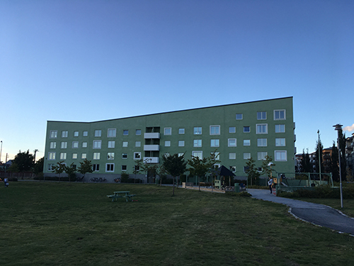 Grönt flerfamiljshus modern arkitektur rakt framifrån