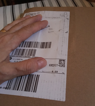 Min hand på ett brunt paket