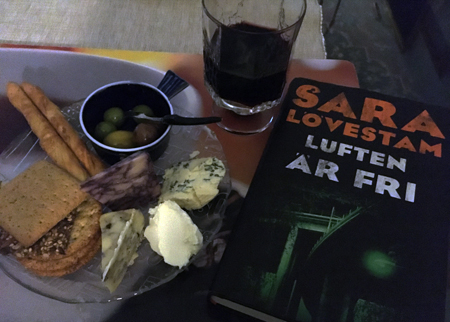 Ostassiett med fyra sorters ost oliver vin och boken Luften är fri Ostassiett med fyra sorters ost oliver vin och boken Luften är fri