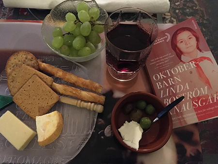 Ostassiett med druvor chianti och boken Oktoberbarn