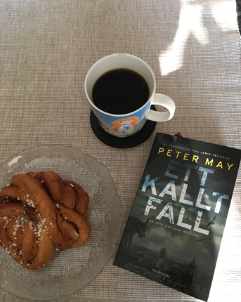 Fika med kanelbulle och boken Ett kallt fall