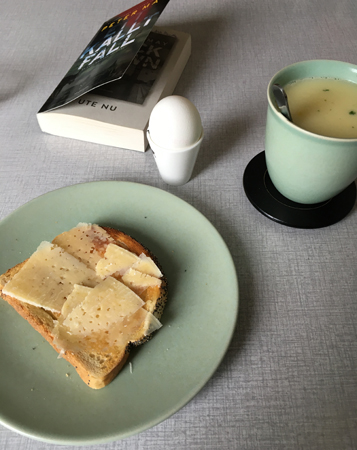 Lunch med rostat bröd ägg varma koppen och boken Ett kallt fall