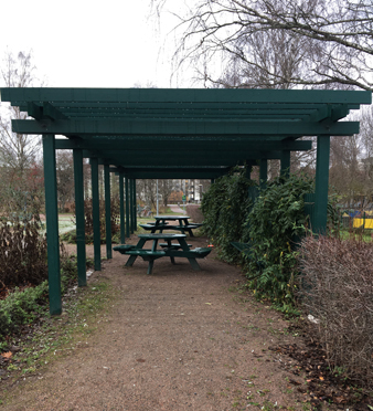 Bänkar och bord i pergolan i Höganäsparken